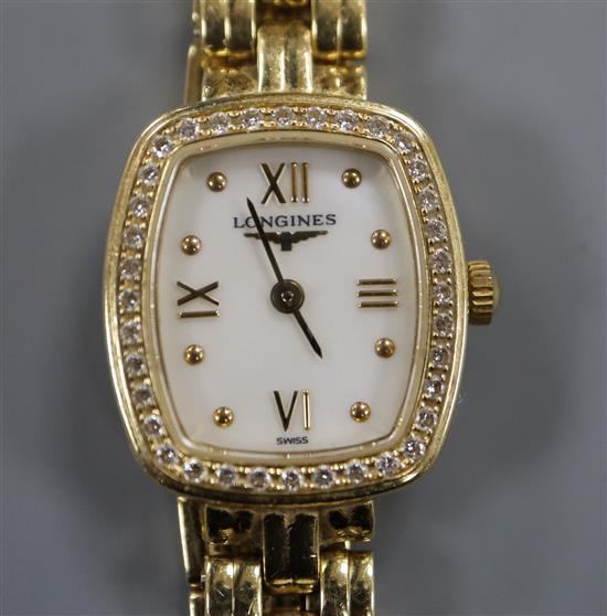 An 18ct gold ladys Longines wristwatch with cushion-shaped grain-set diamond bezel and integral bracelet.